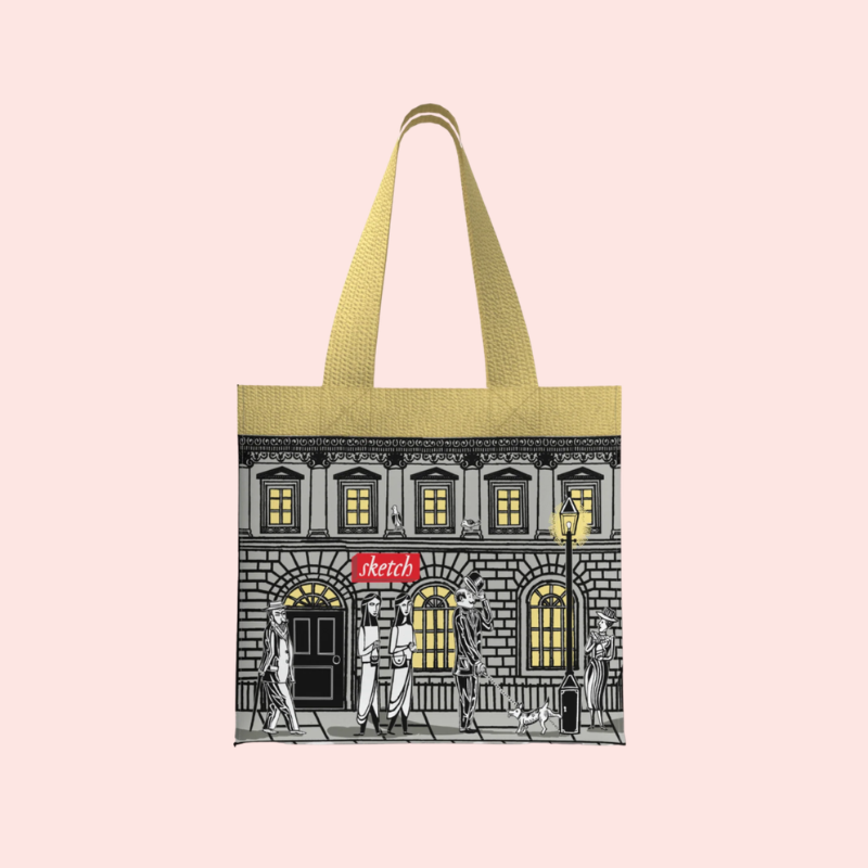 Load image into Gallery viewer, Tote bag with a building design and 'sketch' logo on a yellow background